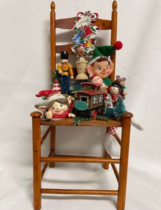 a wooden rocking chair filled with figurines and christmas decorations on top of it