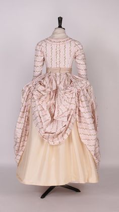 Embrace the grandeur of a bygone era with our Cream and Pink Floral Rococo Dress. This exquisite gown captures the intricate artistry of the Rococo style, enhanced with the noble essence of Victorian ball gowns. It features a rich tapestry of cream fabric blooming with delicate pink florals, each petal a whisper of spring's soft serenade. The bodice, adorned with vintage lace detailing and hand-sewn pearls, showcases a romantic silhouette, while the sweeping skirt offers a dance of elegance and Ball Gown Plus Size, Victorian Style Wedding Dress, Georgian Fashion, Victorian Ball Gowns, Rococo Dress, Waltz Dress, 18th Century Women, Antoinette Dress, Nontraditional Wedding Dress