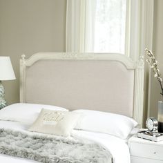 a bed with white sheets and pillows in a bedroom