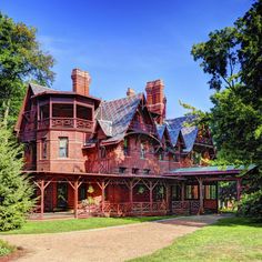 a large red house surrounded by trees and grass