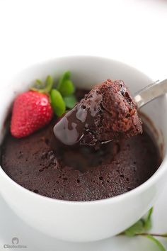 a bowl filled with chocolate pudding and a strawberry