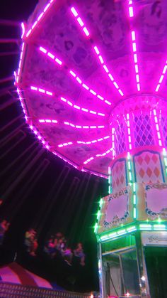 a brightly lit carnival ride at night with lots of lights on the top and sides