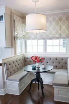 a corner table and bench in a small room