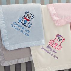 three baby blankets with embroidered teddy bears on them, one is pink and the other is blue