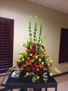 an arrangement of flowers on a black table