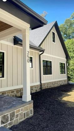 the front of a house with stone steps and pillars on it's side, under a blue sky