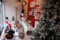 a christmas tree sitting in the corner of a room next to a window with snowmen on it