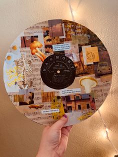 a person holding up a clock made out of old music sheets and paper with words on it