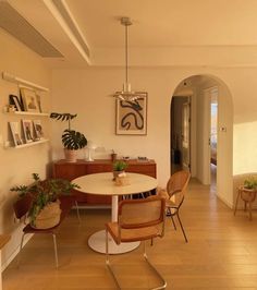 a dining room table with chairs and plants on it