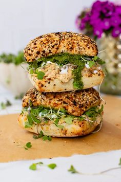 two sandwiches stacked on top of each other with herbs and seasoning in the middle