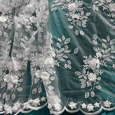 Add a touch of ethereal romance and innocent charm to your next special event with our high-quality Beaded 3D Floral Lace Fabric. This exquisite design, embroidered on 100% polyester net mesh, features 3D satin flowers, each adorned with a delicate pearl at its heart. The design is further enriched by beautifully embroidered leaves that add a touch of nature's elegance. Symmetrical scallops frame the design, decorated with multi sized raised 3D flowers, each one embellished with a pearl beading Elegant Tulle With Floral Embroidery Fabric, Elegant Tulle With Floral Embroidery, Elegant Floral Embroidered Tulle Fabric For Ceremony, Elegant Embroidered Tulle Lace, Elegant Organza Lace With Floral Embroidery, Elegant Floral Embroidered Organza Lace, Elegant Floral Embroidery Organza Lace, Elegant Organza Fabric With 3d Embroidery, Elegant Tulle Fabric With 3d Lace Embroidery