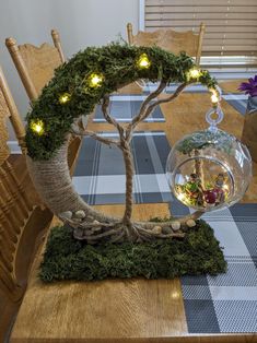 a table with a tree and some lights on it's branches in the center