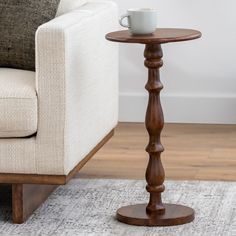 a wooden table with a cup on it next to a couch