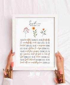 two hands holding up a framed print with the words, flowers and leaves on it