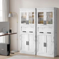 a white cabinet with glass doors is in the corner of a room next to a computer desk