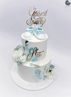 a white cake with blue flowers and shoes on top that says christ & savy