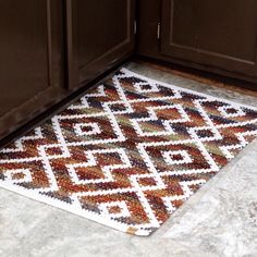 a kitchen with brown cabinets and a rug on the floor