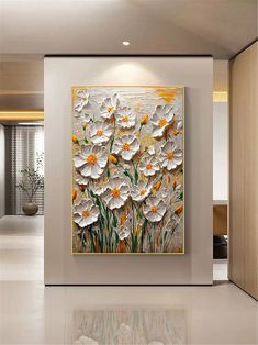 an abstract painting with white and yellow flowers on the wall in front of a living room