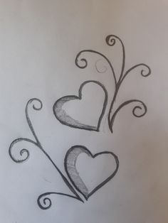 three hearts drawn on paper with swirls