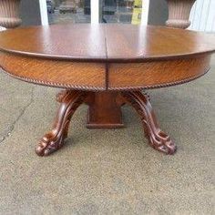 a wooden table sitting on top of a cement floor next to two urn vases