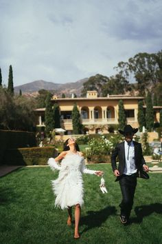 a man and woman walking in the grass