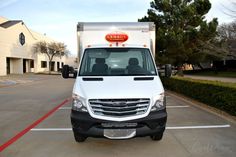 a white delivery truck parked in a parking lot