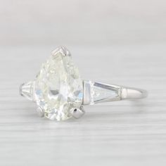 an oval and baguette cut diamond ring with two tapers on each side