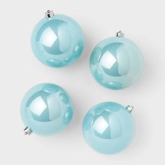 three blue glass ornaments on a white surface