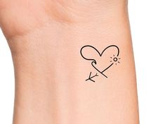 a tattoo on the wrist of a person with a heart and arrow drawn on it