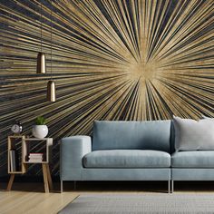 a blue couch sitting in front of a wall with gold and black designs on it