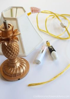 a lamp with a gold pineapple on it next to some other items and cords