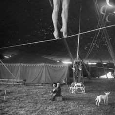 a man is hanging upside down in the air with his feet dangling from a rope