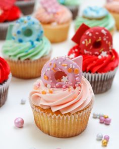 cupcakes with frosting and sprinkles are arranged on a table