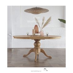 a wooden table sitting on top of a hard wood floor next to a potted plant