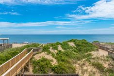 an ocean view from the top of a beach house on stilts above sand dunes