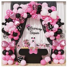 a birthday party with balloons and minnie mouse decorations on the front wall, along with an arch that says happy birthday squad