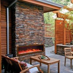 an outdoor patio with wood furniture and a fire place