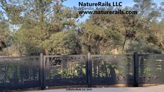 an iron fence with trees in the background