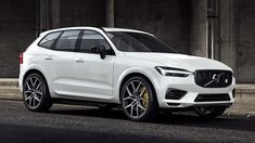 a white volvo suv parked in front of a building