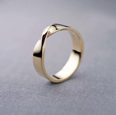 a gold wedding ring sitting on top of a table