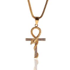 Available in both a gold and silver finish, this lovely Ankh pendant design incorporates the old ancient Egyptian hieroglyphic with a figure of a slithering snake. As the snake wraps around the sign, it also makes the upper loop of the symbol. This unique combination of design components makes this piece innovative. The snake is intricately detailed with the scales carved into its metallic body. The remaining portions of the pendant are covered in tiny cubic zirconia crystals. This Innovato Design piece is crafted from 316L stainless steel metal.  Product Highlights    Chian link necklace included  Unique Snake and Ankh Pendant Design  Stunning Cuc Zirconia Crystals Slithering Snake, Ancient Egyptian Hieroglyphics, Ankh Pendant, Wood Inlay Rings, Crystals Necklace, Punk Accessories, Masonic Ring, Gothic Rings, The Snake