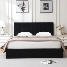 a bedroom with white walls and black headboard on the bed is pictured in this image