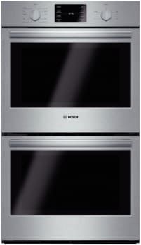 two ovens side by side, one with the door open and one with the light on