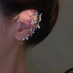 a close up of a person wearing some kind of ear cuff with flowers on it