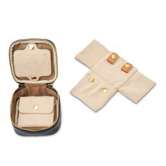 an open case with two pieces of cloth in it on a white surface next to some gold buttons