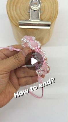 a person is holding a pink beaded object with the words how to end?