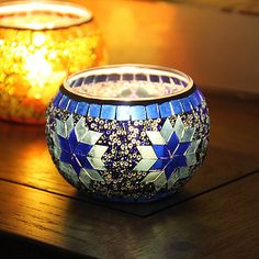 two lit candles sitting next to each other on a table