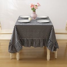 a black and white checkered table cloth with flowers in a vase