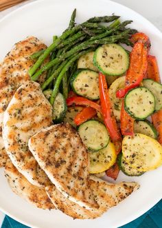 grilled chicken, asparagus and carrots on a white plate with green beans