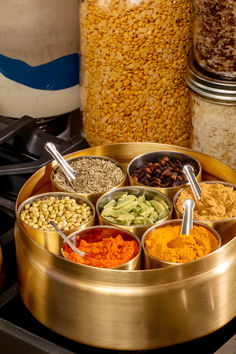 an assortment of spices in bowls on a stove